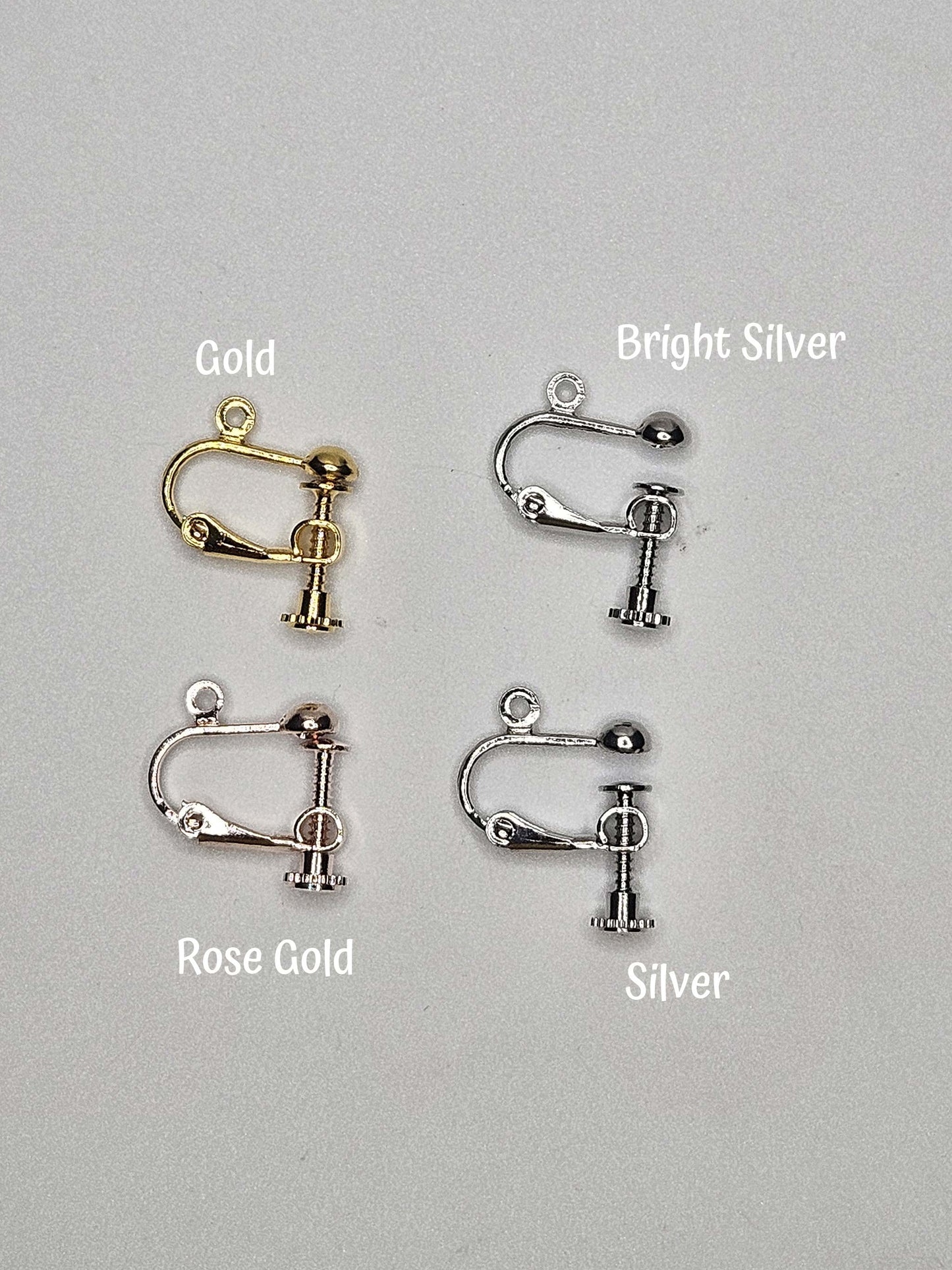 Four earring clips in gold, bright silver, rose gold, and silver on a gray background.