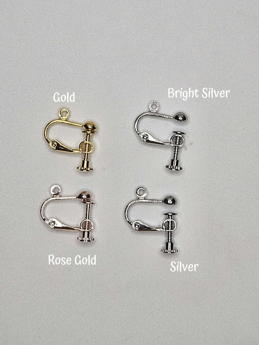 Four earring clips in gold, bright silver, rose gold, and silver on a gray background.