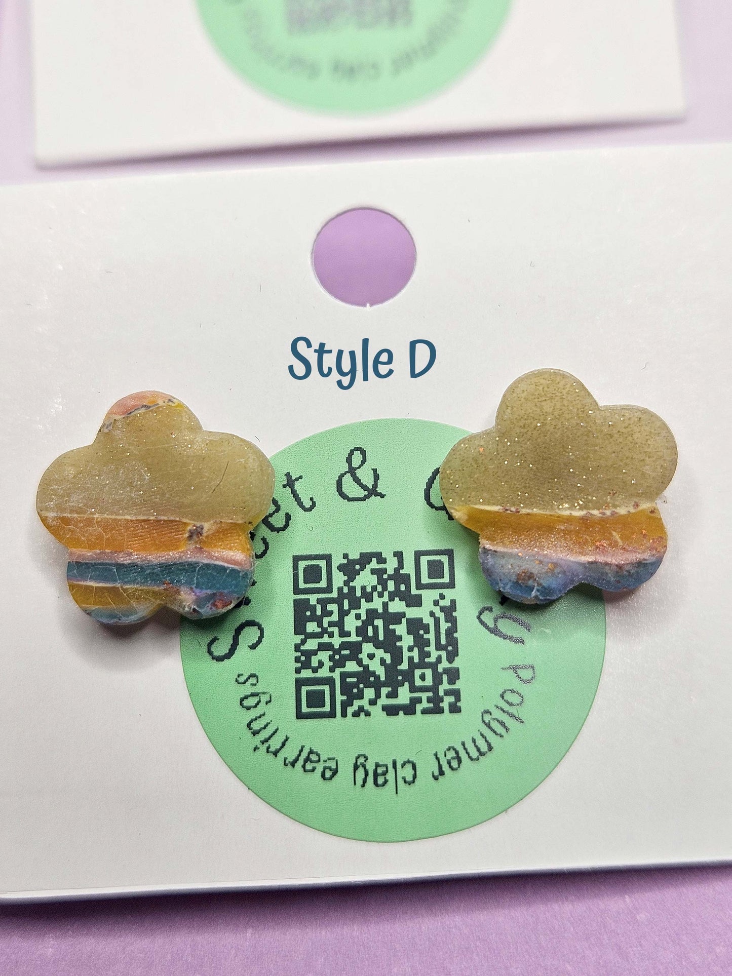 Butterfly-shaped earrings on a card with a QR code and brand name.