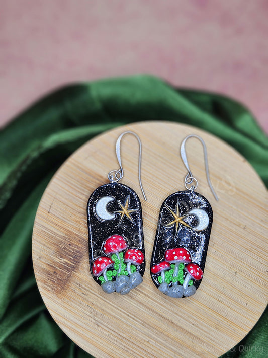 Pair of earrings with mushroom design on a wooden stand