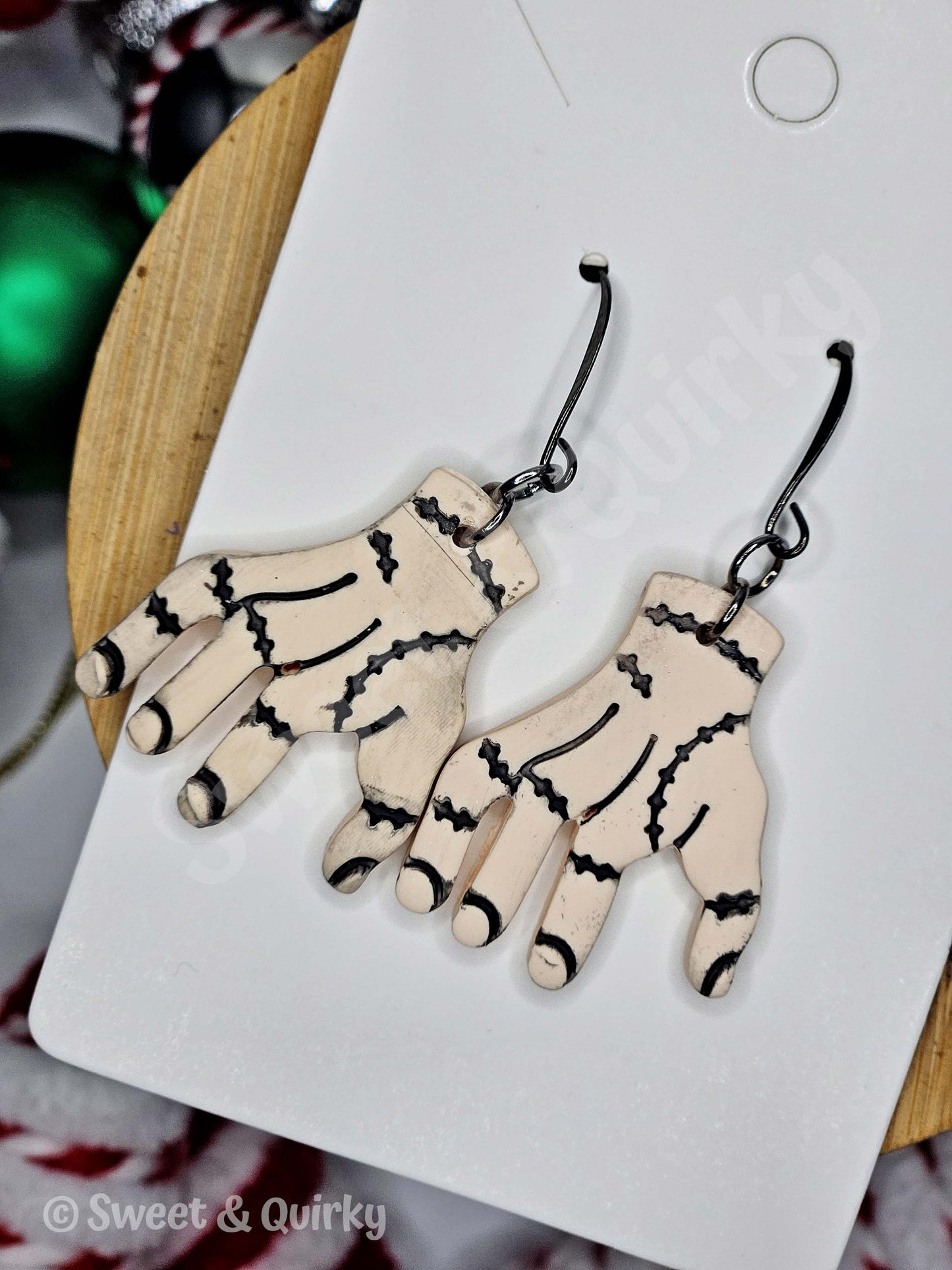 Hand shaped earrings with black stitching like Thing from the Addams Family TV show.