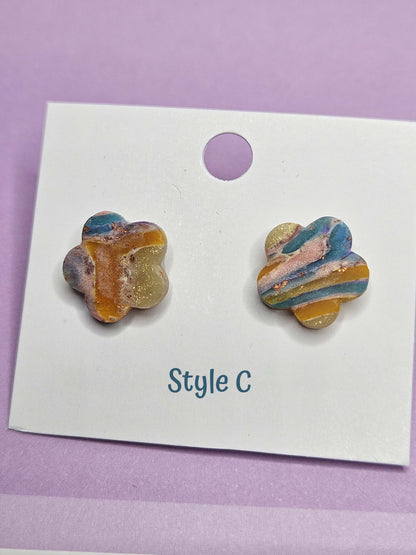 Colorful flower-shaped earrings on a white card with 'Style C' text, against a purple background