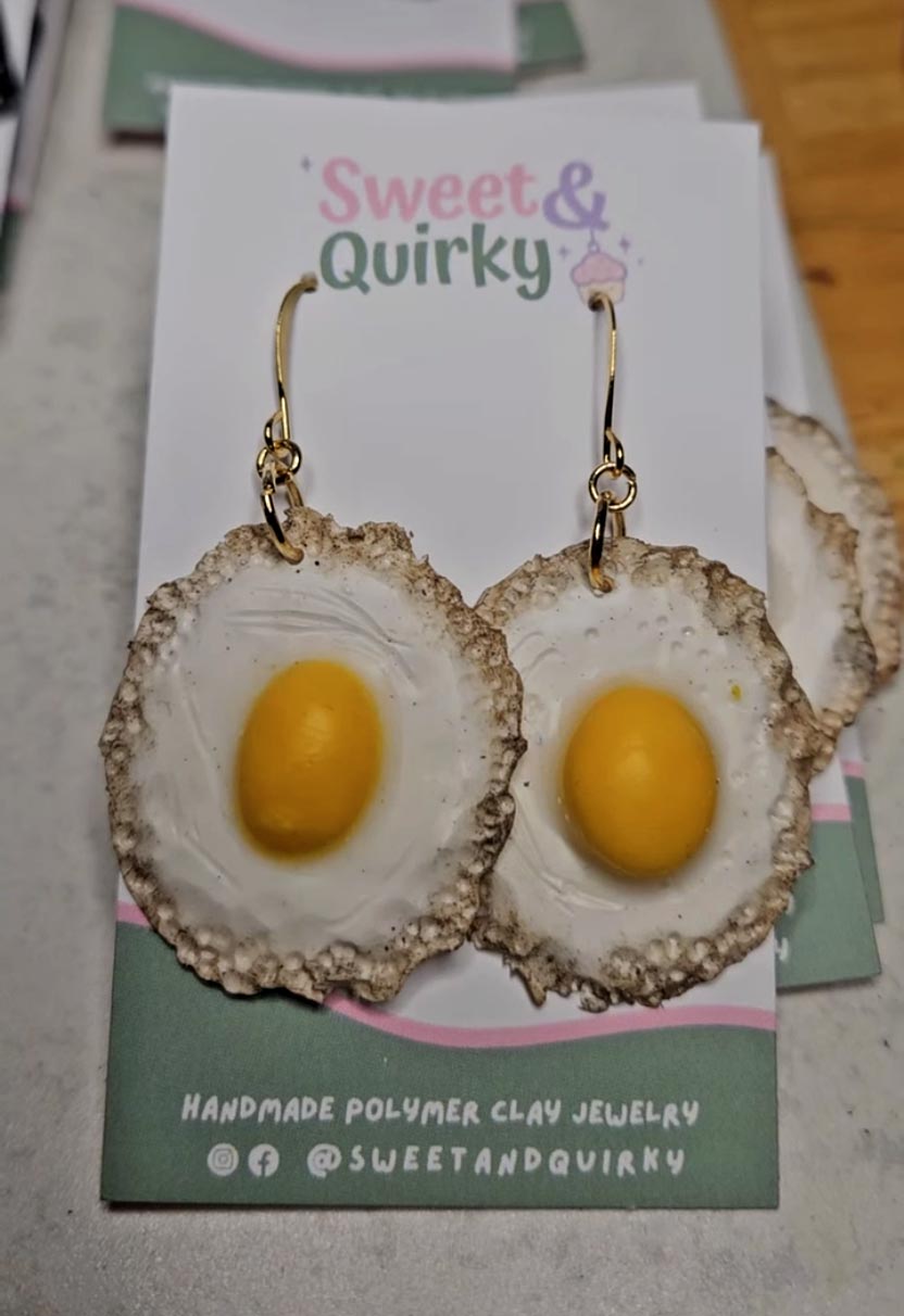 Egg-shaped earrings on a 'Sweet & Quirky' branded card.