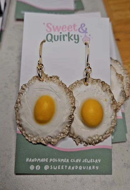 Egg-shaped earrings on a 'Sweet & Quirky' branded card.