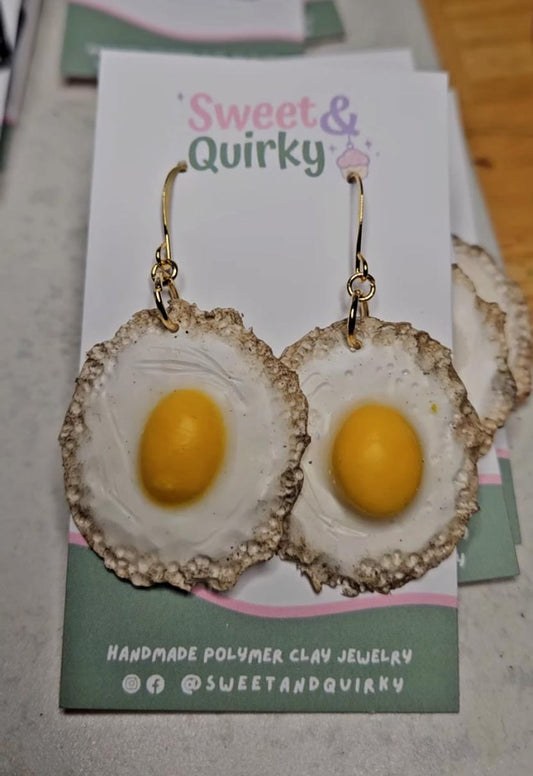 Egg-shaped earrings on a 'Sweet & Quirky' branded card.