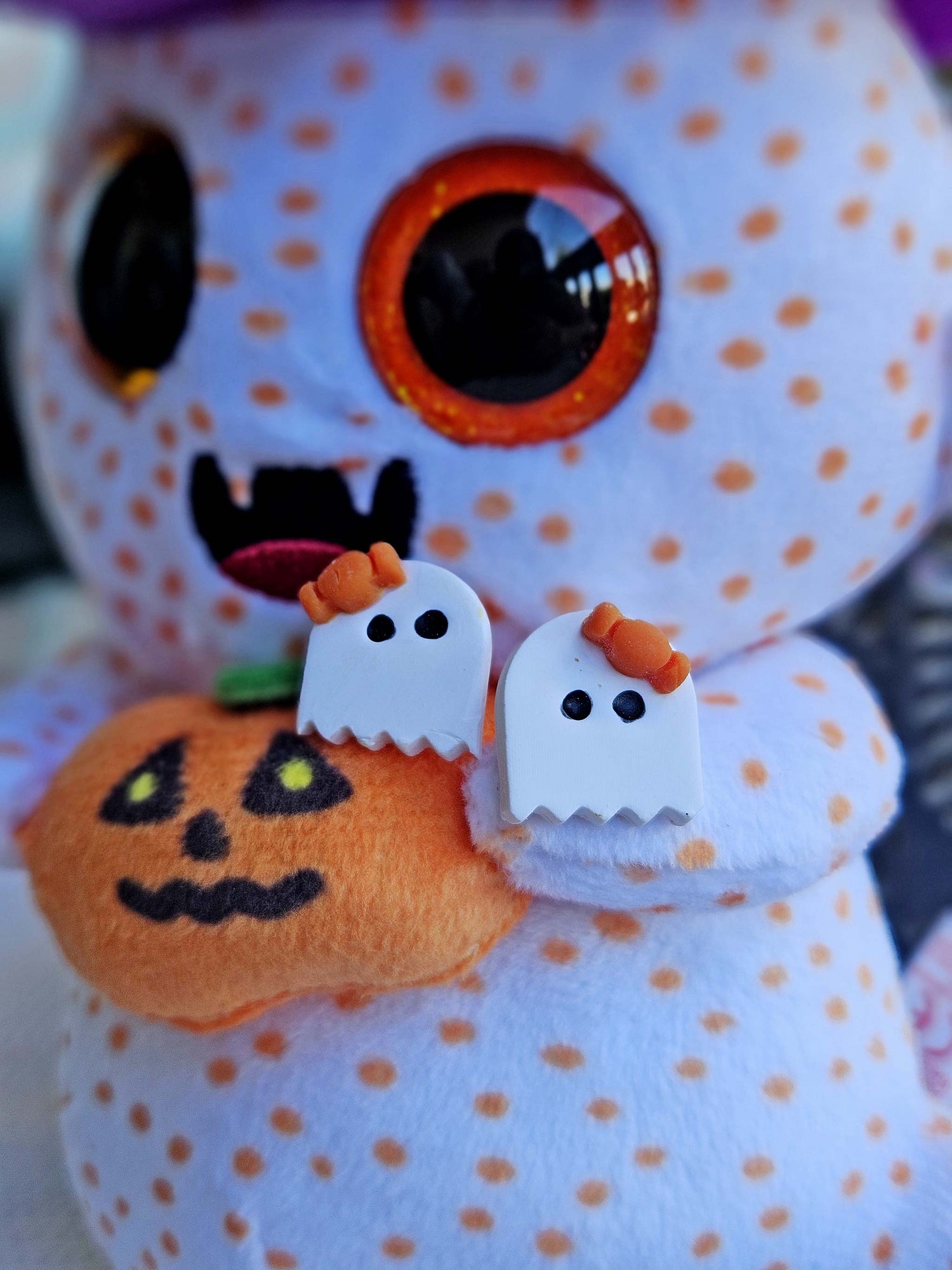 Halloween-themed plush toy with ghost and pumpkin decorations on a white background