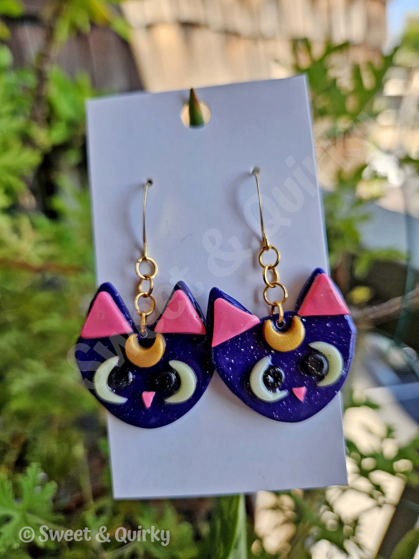 Sailor Moon - Luna cat-shaped earrings with purple, pink, and gold colors.