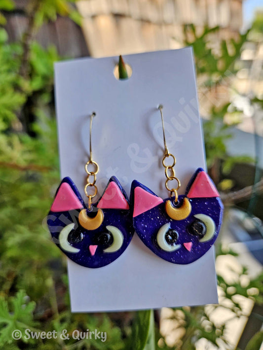 Sailor Moon - Luna cat-shaped earrings with purple, pink, and gold colors.
