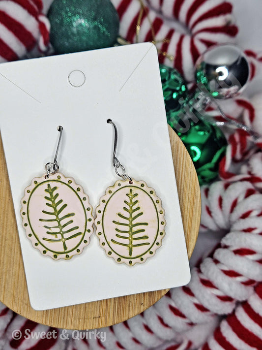 Earrings with tree design on a Sweet & Quirky branded card with Christmas-themed background