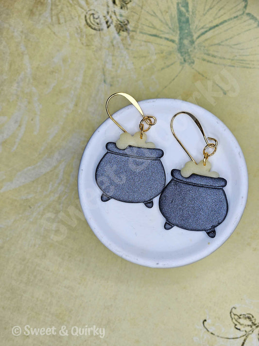Pair of earrings on a round white card with 'Sweet & Quirky' branding.