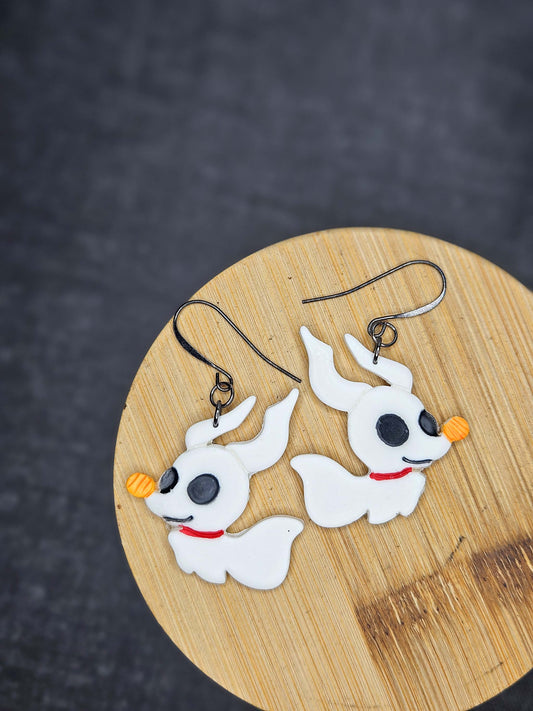 Pair of ghost cartoon dog-shaped earrings on a wooden board with a dark background